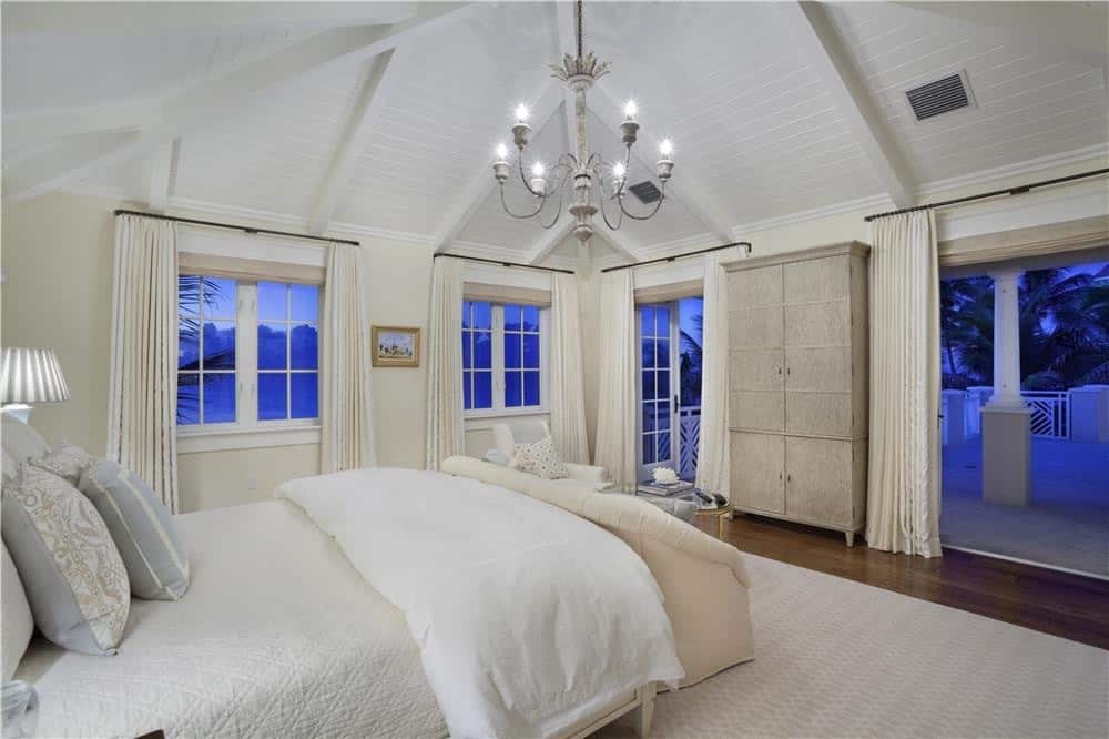 all white Master bedroom with exposed wood ceilings