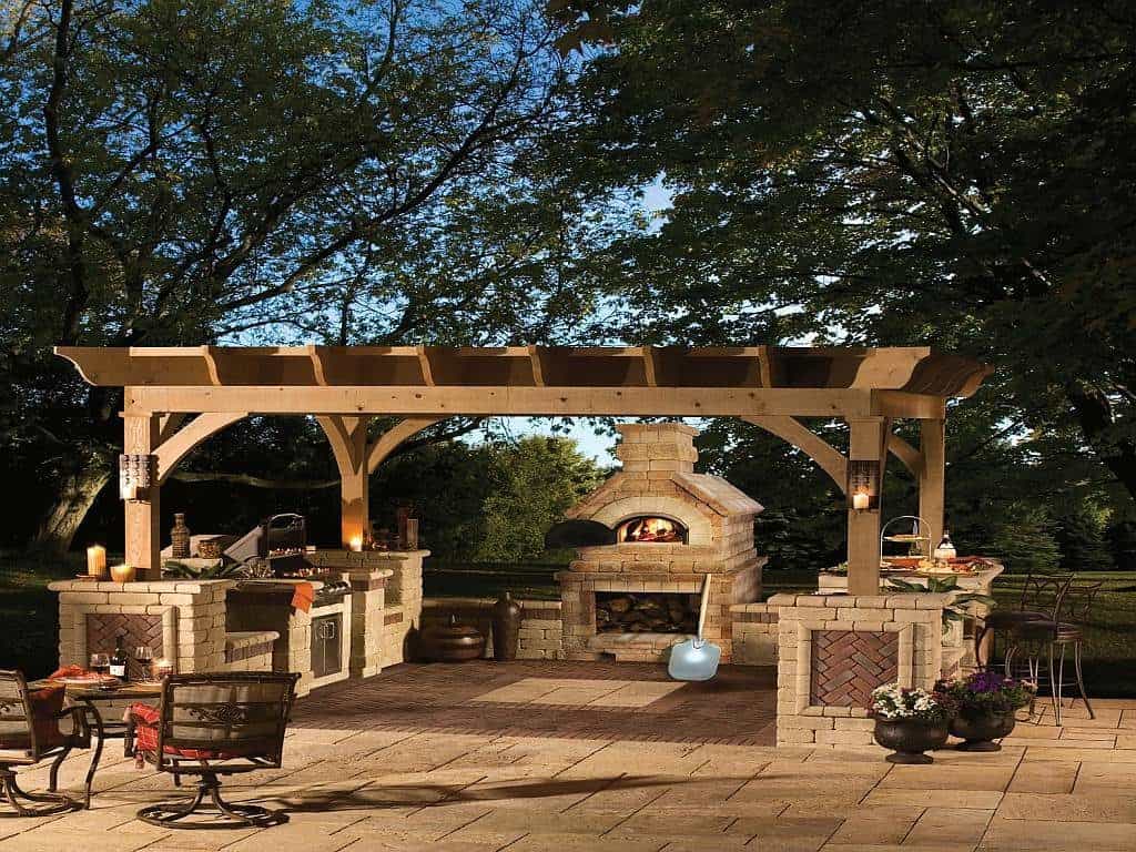 Stone backyard patio design with overhead pergola and fire pit