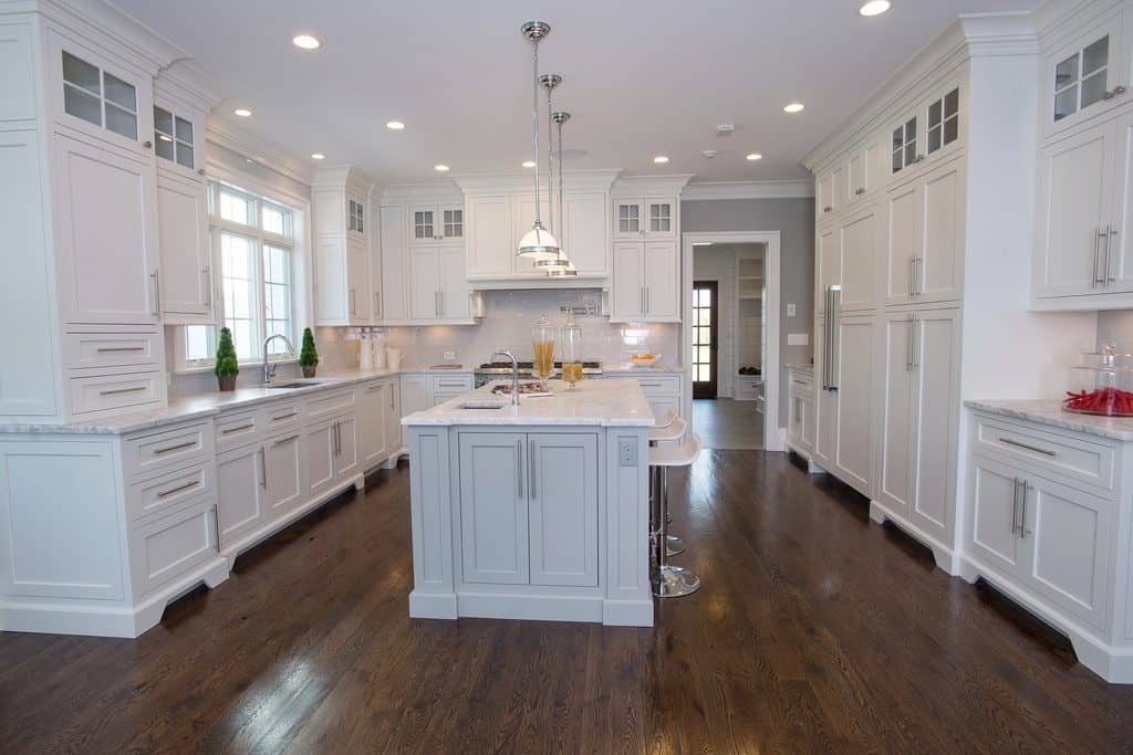 Traditional white kitchen cabinets with silestone quartz countetops and dark strand oak flooring