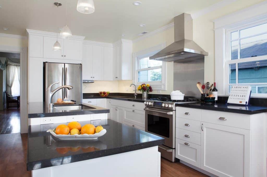 White kitchen cabinets with black recycled glass countertops