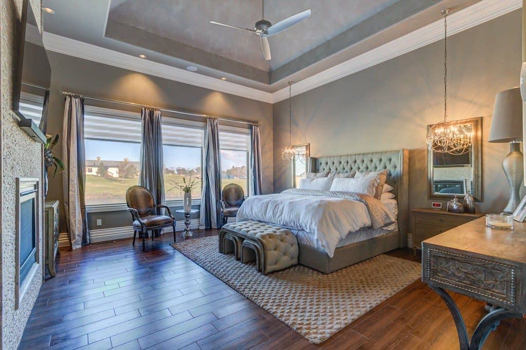 Professionaly designed master bedroom with a traditional style with wood flooring and high ceilings