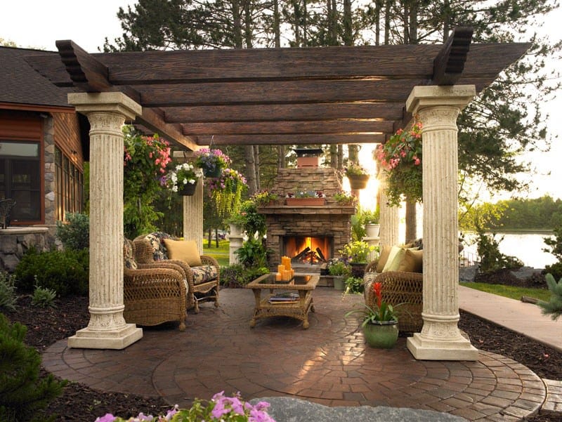 Traditional brick patio with pergola and stone veneer fireplace