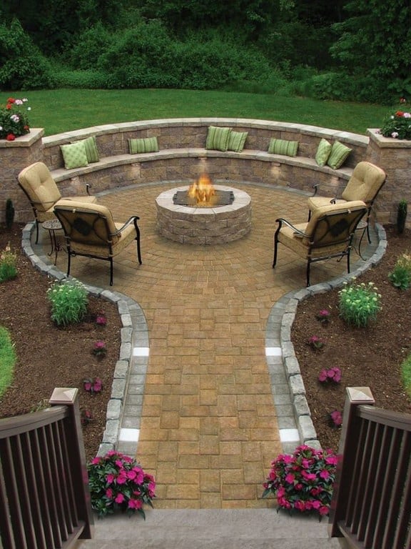 Traditional backyard patio with curved stone seating and fire pit
